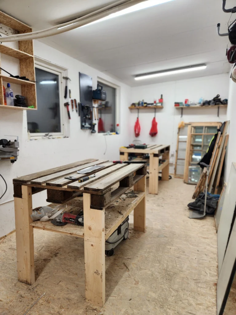 Nybyggda arbetsbänkar, verktygstavla och uppställda fönster i Fönstrias nya verkstad